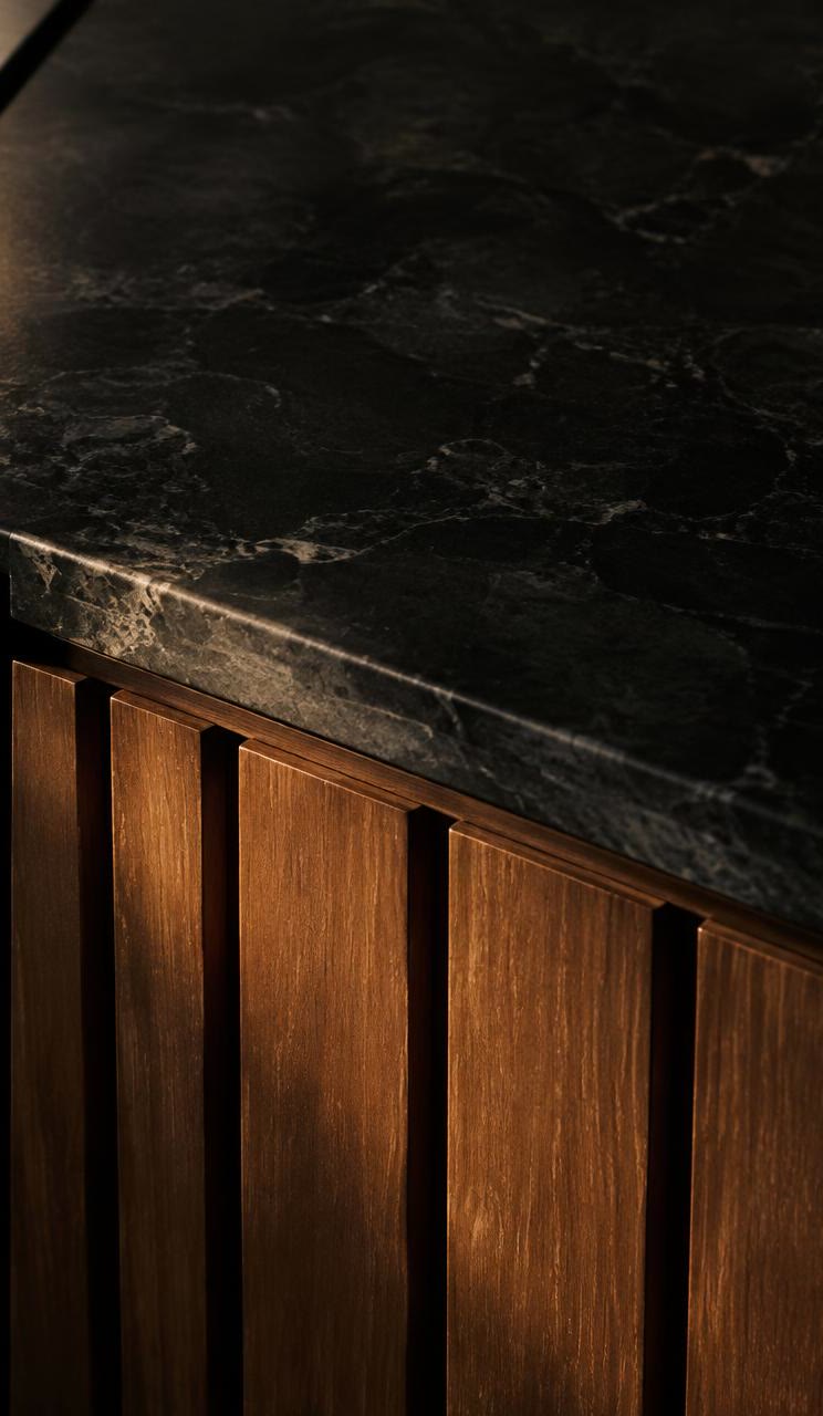 Close-up of brushed steel, teak slats and dark stone worktop